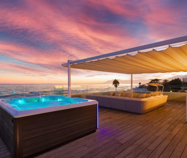 Luxuriöse Rooftop-Terrasse einer Villa in Marbella mit Meerblick bei Sonnenuntergang